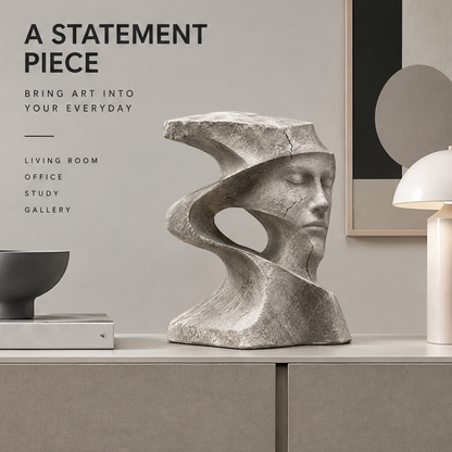 Spiral face sculpture styled on a console beside books, a black bowl, a lamp, and framed art